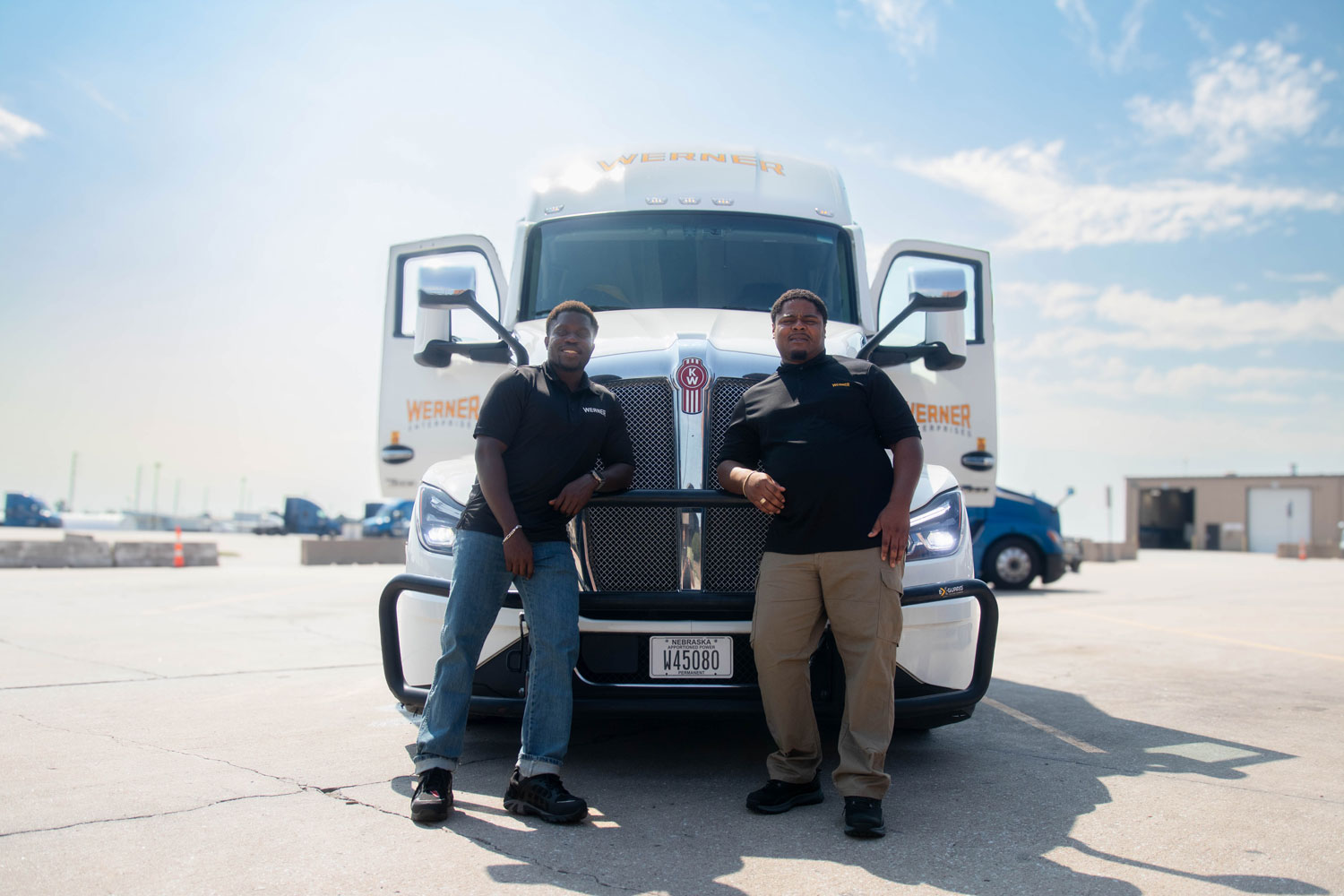 team-driving-06 Two Werner Enterprises team drivers posing in front of their semi-truck.